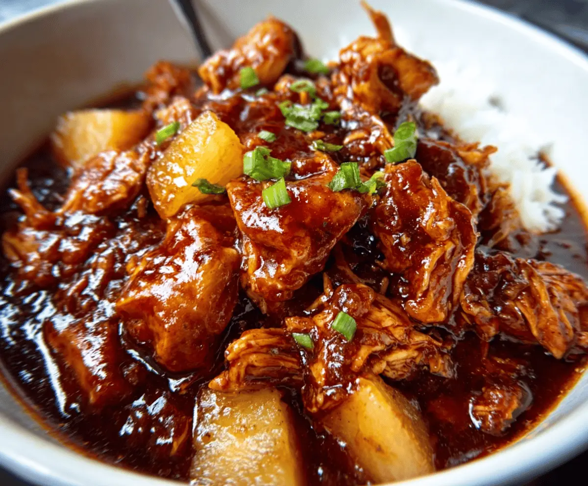Delicious Crockpot Pineapple BBQ Chicken served on a plate with fresh herbs and vegetables
