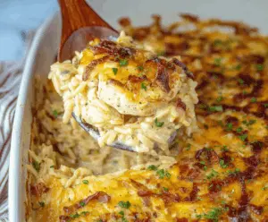 Creamy French Onion Chicken Orzo Casserole topped with melted cheese and caramelized onions, served in a baking dish for a comforting, flavorful meal.