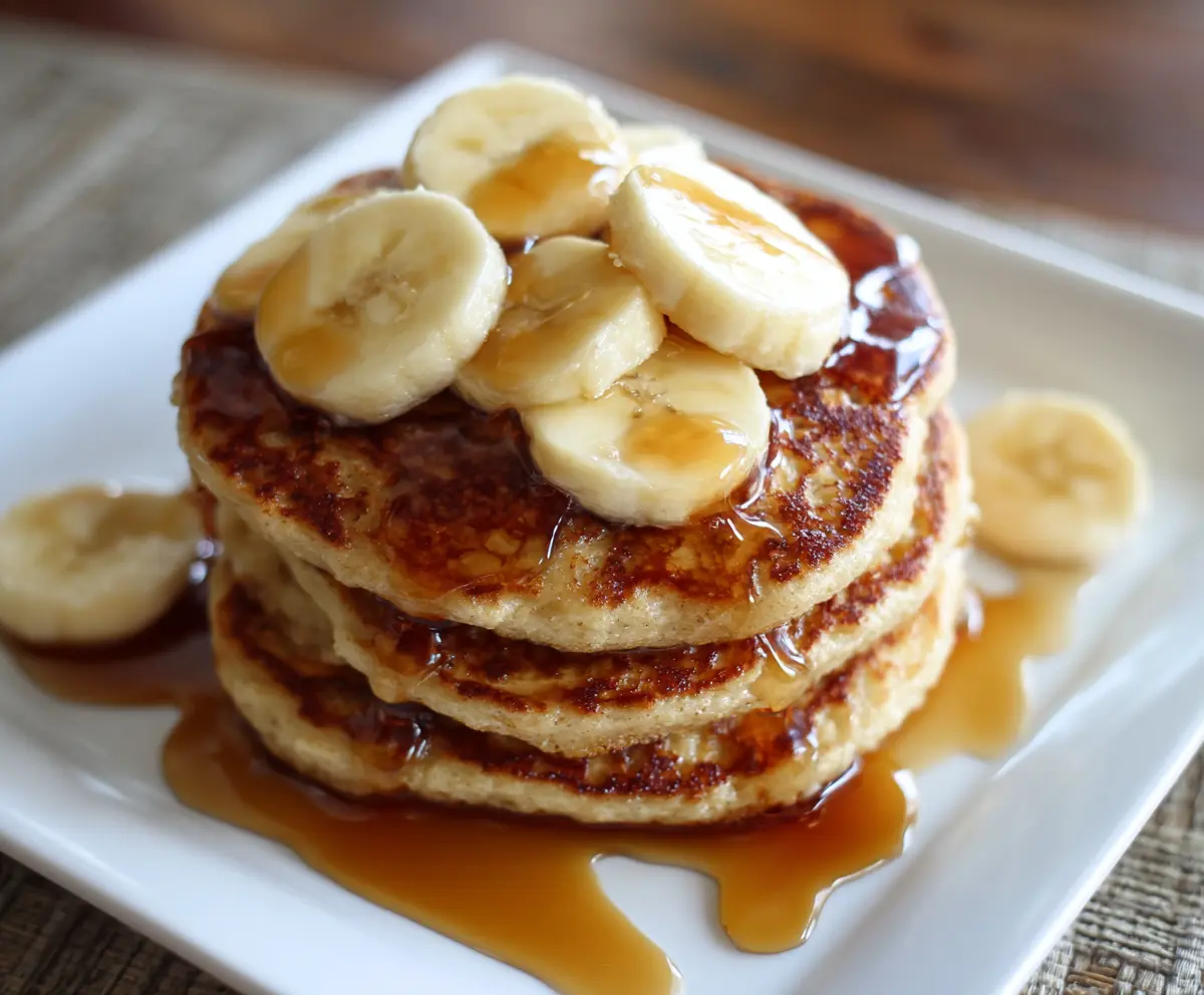 Delicious 3 Ingredient Banana Oatmeal Pancakes served on a plate with fresh fruit.
