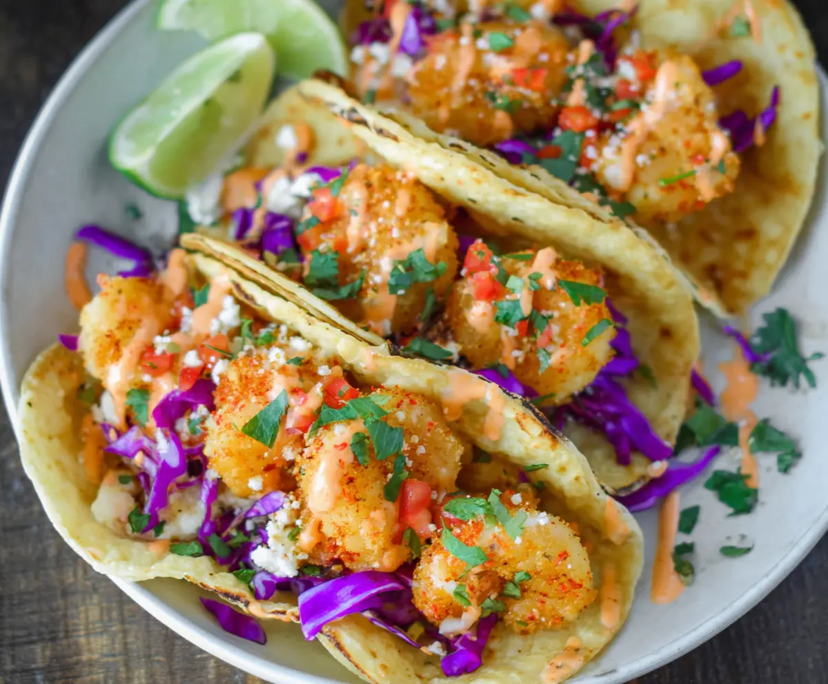 Delicious Air Fryer Bang Bang Shrimp Tacos with crispy shrimp and fresh toppings on a plate.