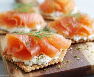 Delicious smoked salmon cream cheese crackers served on a platter for appetizer or snack.